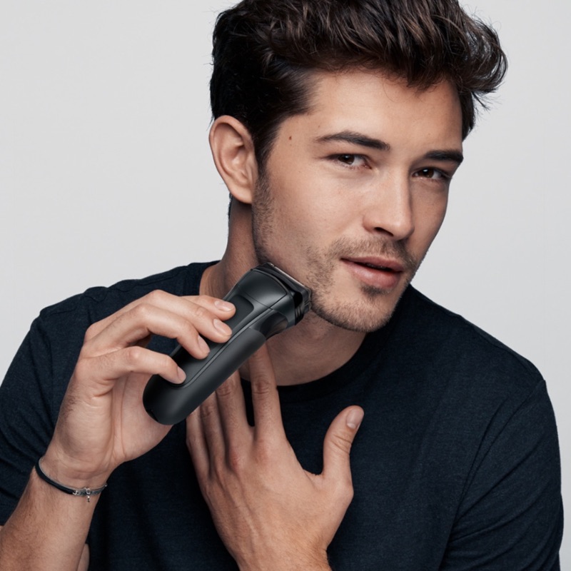 Man som använder rakapparat Rakapparat